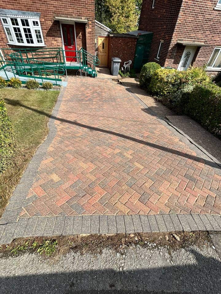 The same driveway after cleaning, the warm red and brindle blocks showing in the sun