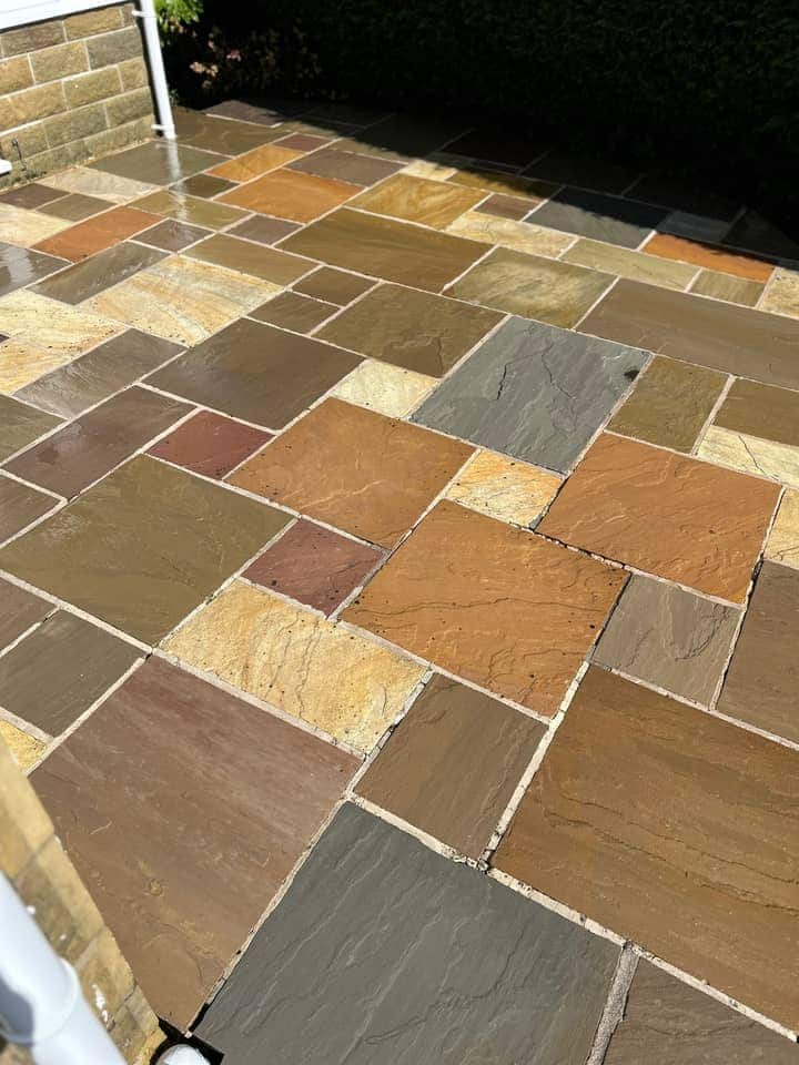 Indian stone patio after cleaning, the slabs showing rust, buff, grey and plum colours