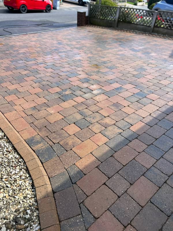Brindle block-paved drive with a curved kerb and gravel edge, after cleaning