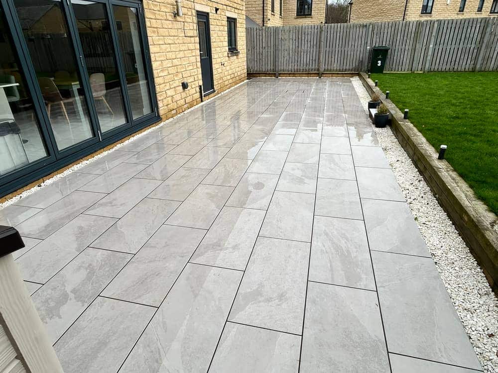 The same porcelain patio after cleaning, the slabs evenly pale grey